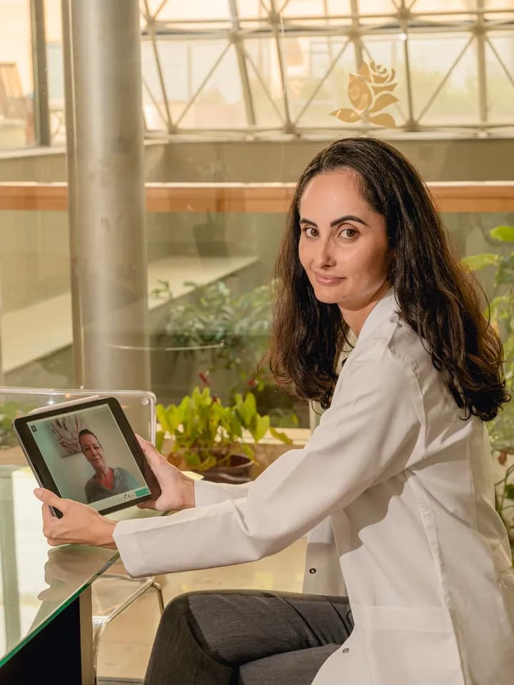 A clinician at Carisma reviewing a consultation on a tablet